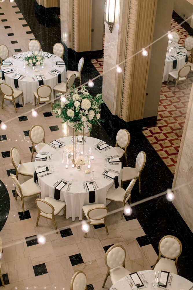 Tall white floral centerpiece on a round reception table in the Stifel Theatre Grand Lobby