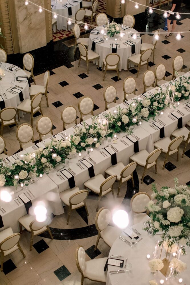 Long wedding head table with white floral hedge and candles in the Stifel Theatre Grand Lobby