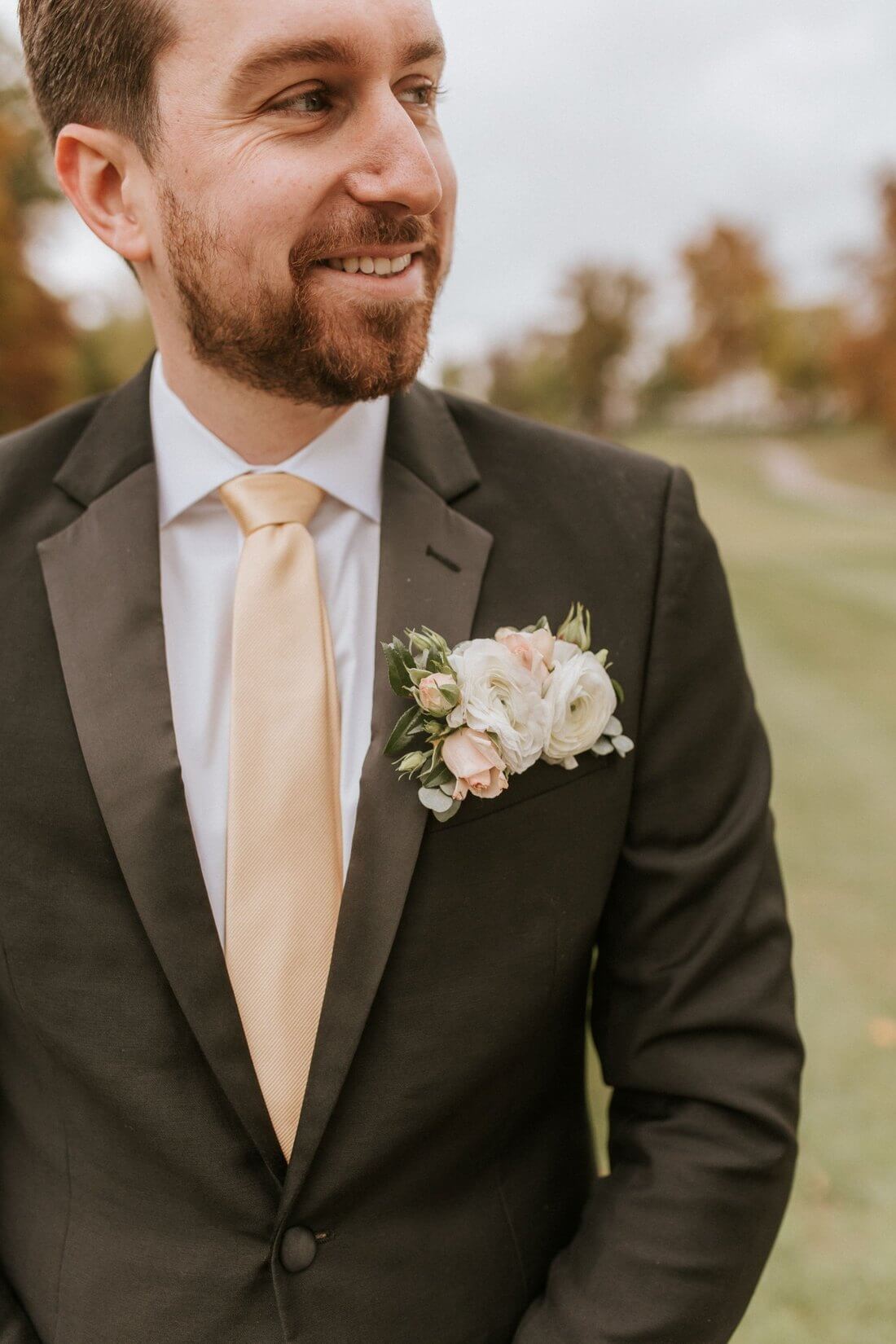 Groom wearing a blush and white pocket boutonniere with floral buds and eucalyptus