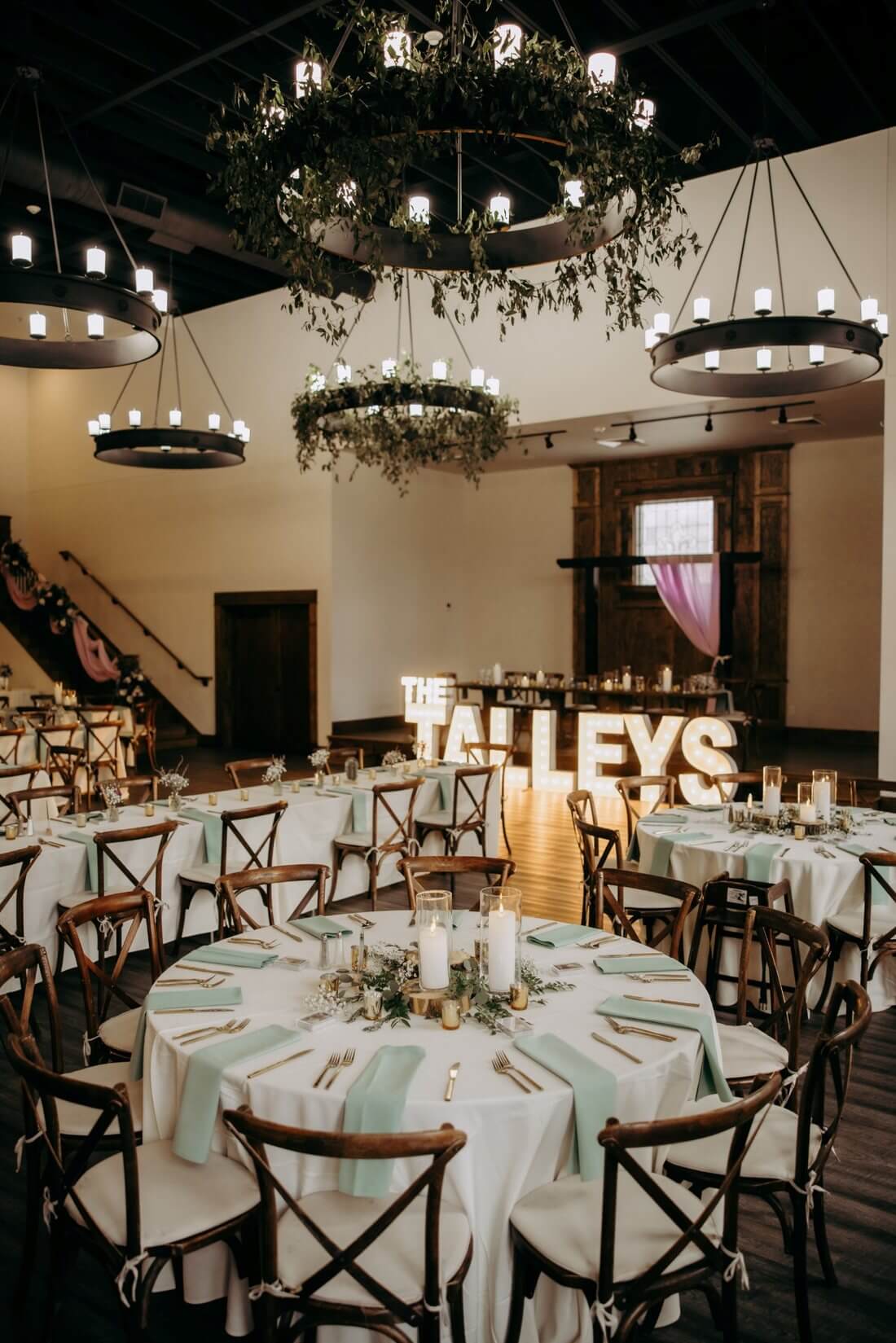 Silver Oaks Chateau ballroom with greenery chandeliers, reception tables, candles, and floral decorations