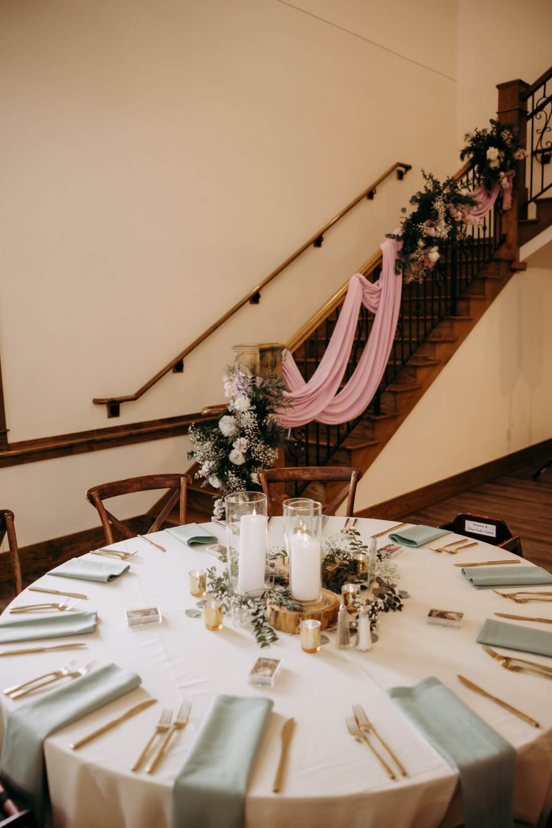 Wedding reception table with mint napkins, candles, and floral staircase at Silver Oaks Chateau