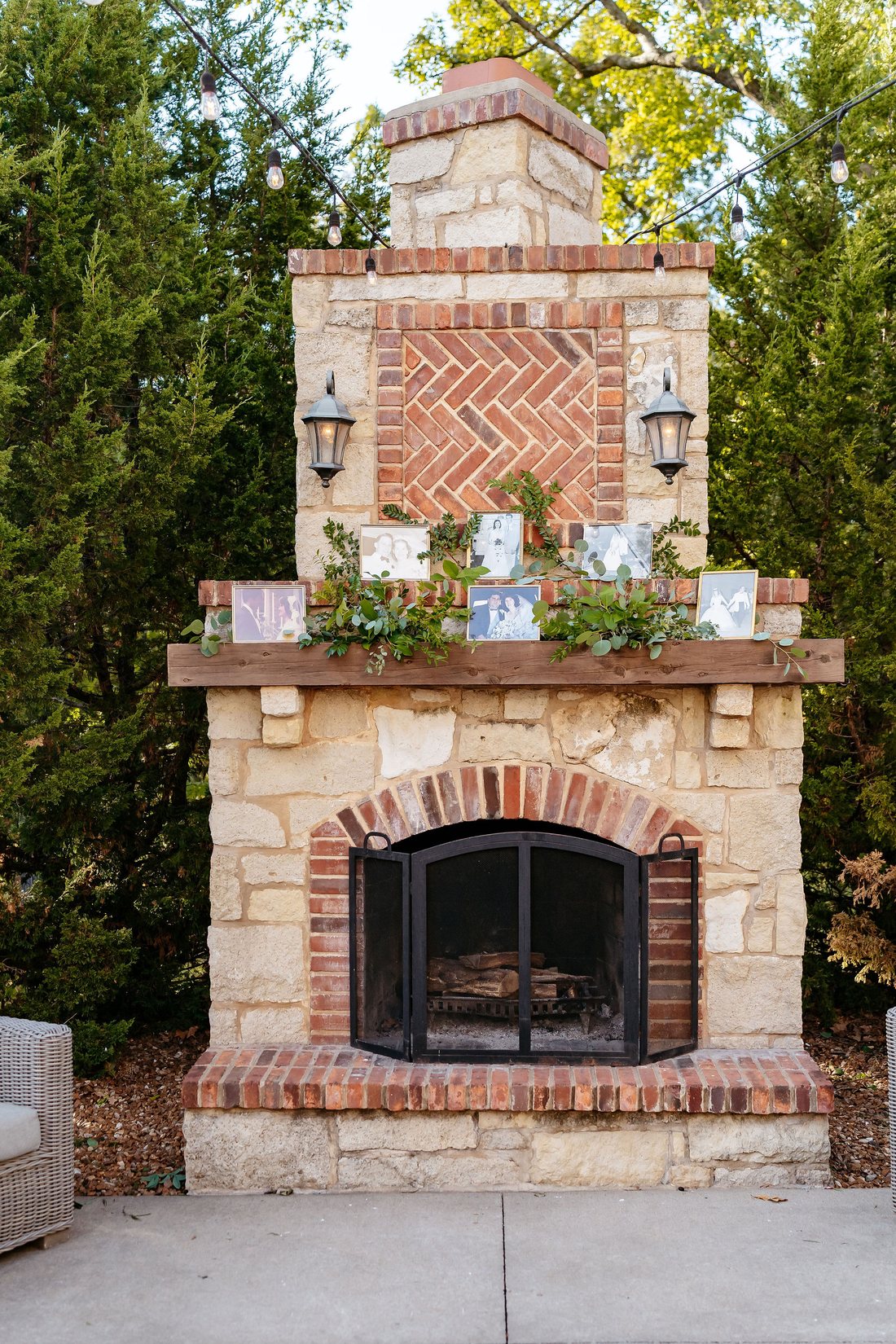 Wedding memory display with framed family photos and greenery on a fireplace