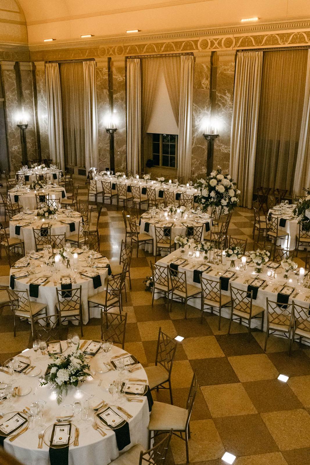The Coronado ballroom decorated with white wedding flowers, gold accents and candlelight