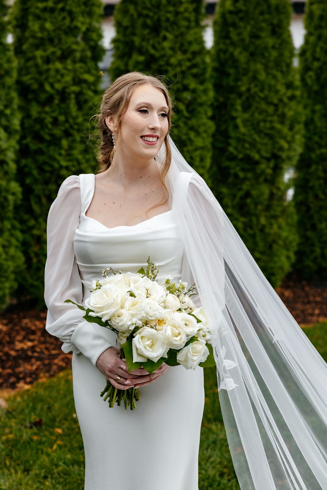 Bride holding an ivory garden rose and ranunculus wedding bouquet