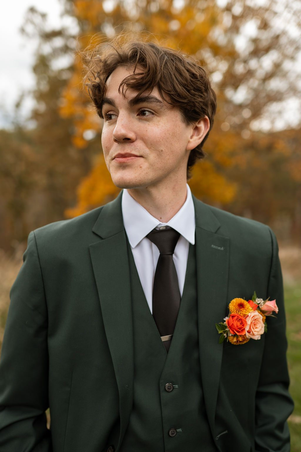 Groom in green suit with autumn floral pocket boutonniere at Silver Oaks Chateau